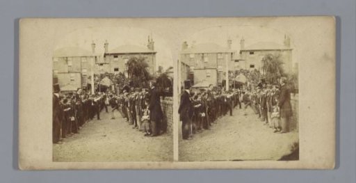 Bride and groom under an arch of honor between a hedge of people