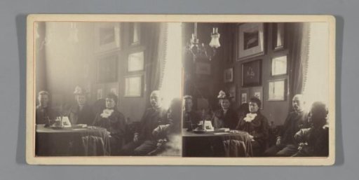 Group portrait in a living room with a stereoscope and photos on the table