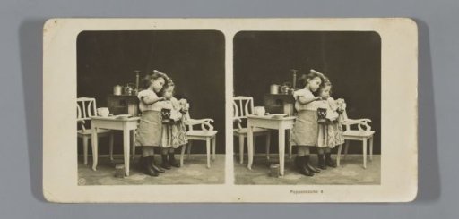 Two girls playing with a toy kitchen