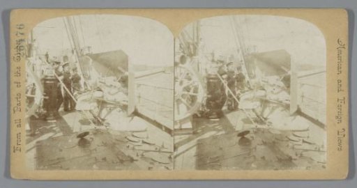 Sailors next to a machine gun on a ship