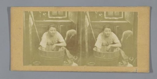 A woman leaning over a wash tub