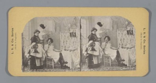 Two women, one scantily clad, beside a dressing table