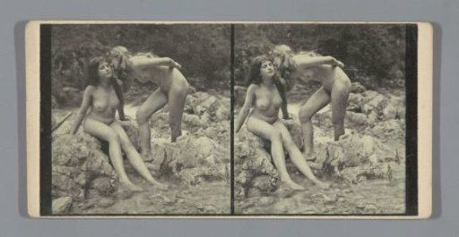 Two nude young women in a riverbed