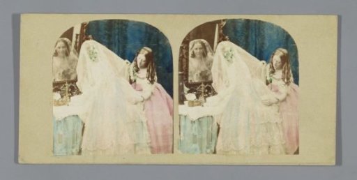 Bride and bridesmaid before a mirror