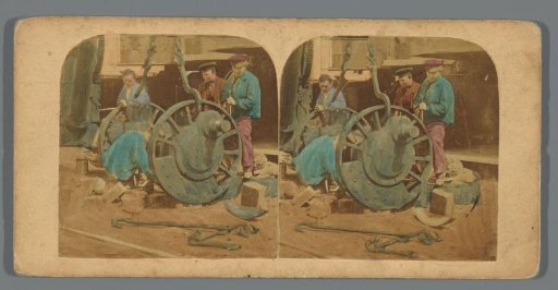 Four men are turning the wheels of a cart