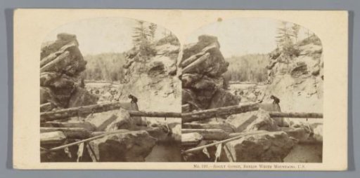 Man Climbing a Rock near the Waterfall Rocky Gorge in the White Mountains, New Hampshire