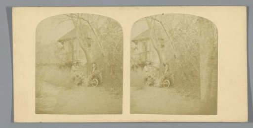Man, woman and child, in front of a house in a wooded area