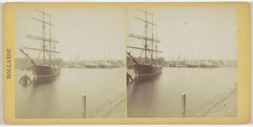 View of a town and a harbour with a ship in the foreground