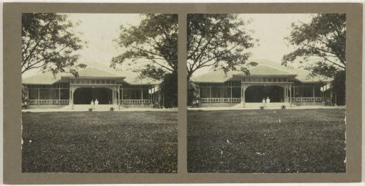 Man and woman posing in front of a country house, possibly in Borneo
