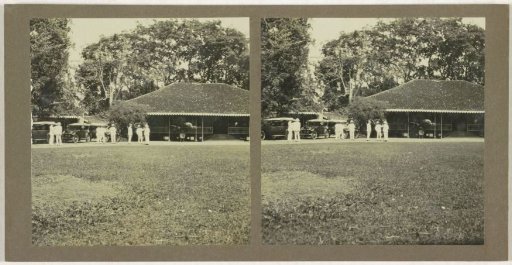 Country house with several men and cars in front of it, possibly in Borneo
