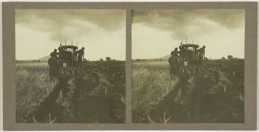 Ploughing machine with farm workers, possibly in Borneo, Indonesia