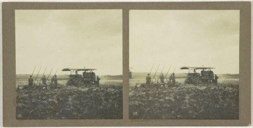 Ploughing machine with farm workers, possibly in Borneo, Indonesia