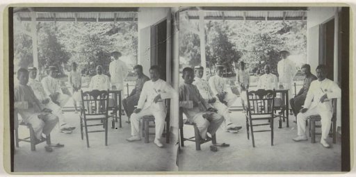 Seven men and a child on a veranda in Manokwari, West Papua