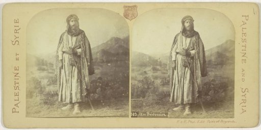 Posing Bedouin before a painted background with mountain landscape