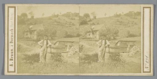 Man beside a wooden barrel in a hilly landscape, possibly in Germany