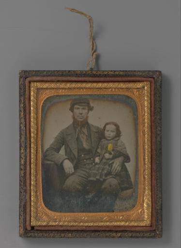 Portrait of an unknown man with a girl on his lap