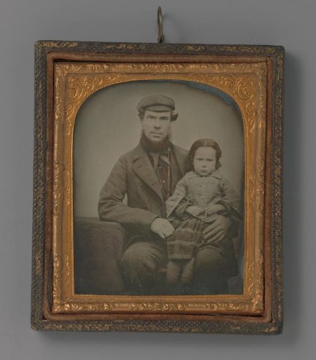 Portrait of an unknown man with a child on his lap