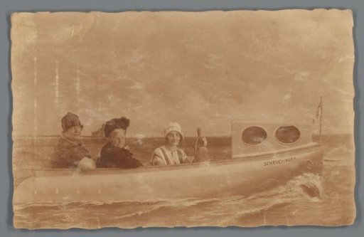 Group portrait of three unknown women in a setting with a painted boat