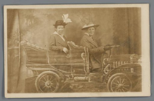 Portrait of two unknown women in a setting with a painted car