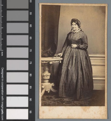 Portrait of an unknown woman, standing beside a table on which a book lies