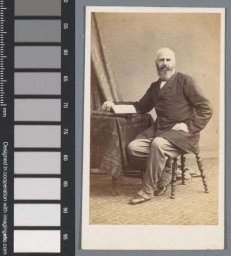 Portrait of an unknown man, sitting at a table with a book under his hand