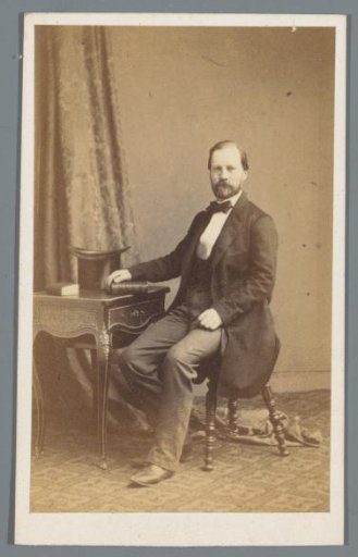 Portrait of an unknown man, seated at a table with a book