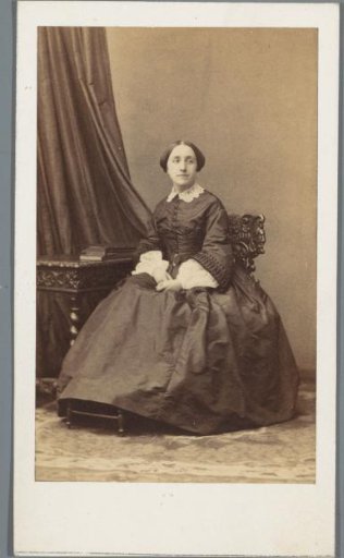 Portrait of an unknown woman, seated at a table
