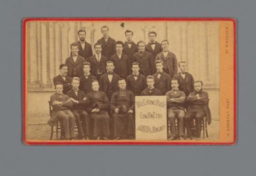 Group portrait with about twenty young men and several Catholic priests, in the foreground a board with the inscription: 'Dilectione usque conjunctos quid disjungat?'