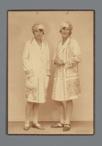 Two mannequins with embroidered capes and caps from the Wiener Werkstätte