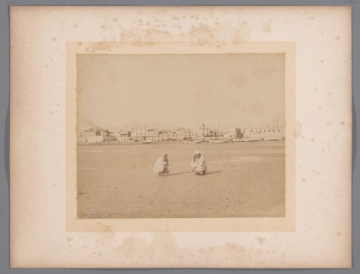 Two men in the harbour of Suez at low tide