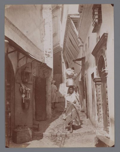 Unknown woman in an alley, possibly in Egypt.