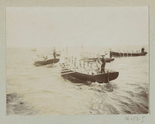 Sailors rowing in rowboats at sea
