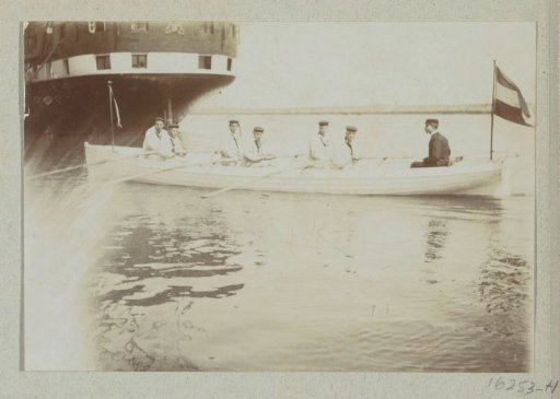 Sailors rowing in a boat towards their ship