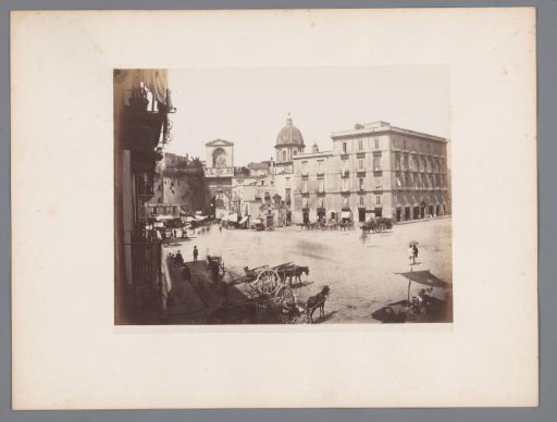 View of a square with the Porta Capuana and the dome of the Santa Caterina a Formiello in the background in Naples, Italy