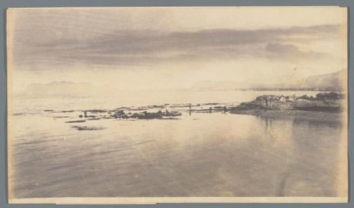 Coastal view of Sicily, with a few fishing boats on the beach to the right