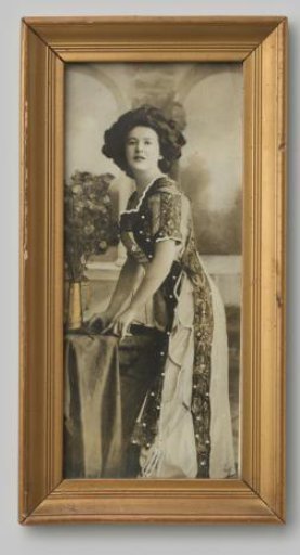 Portrait of an unknown woman leaning on a table with a vase of Judas pennies