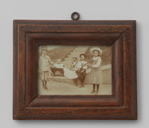 Group portrait of three unknown boys, an unknown girl, and an unknown toddler in a pram