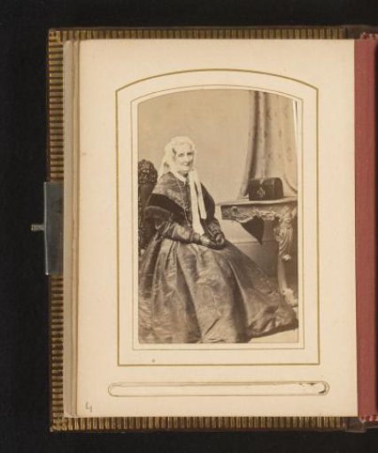 Portrait of a seated woman, wearing gloves