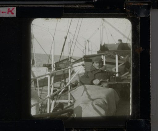 Man Lying Under a Blanket on the Deck of a Ship