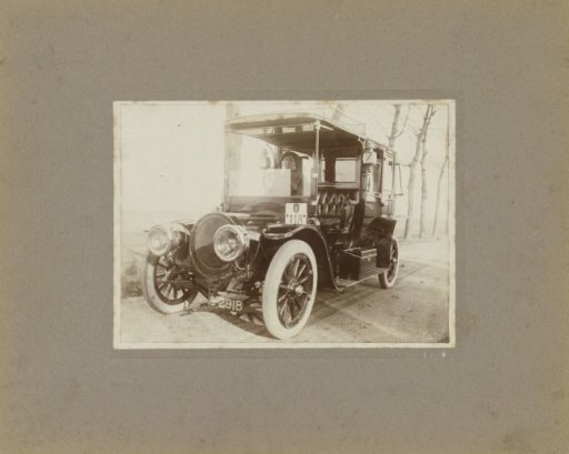 Man in Automobile, Number 118, in Front of House