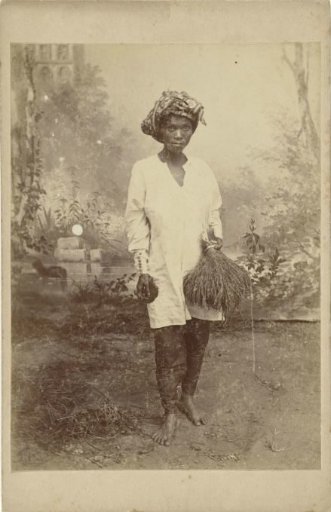 Studio portrait of an unknown Buginese woman with rice in her hand
