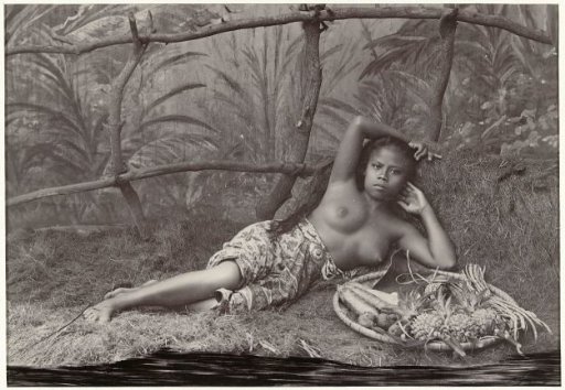 Portrait of an unknown Indonesian half-naked woman, lying with a fruit basket in a setting
