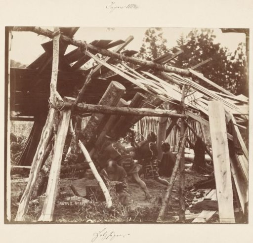 Four people building a wooden house