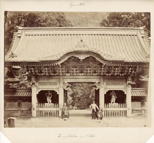 Western-dressed man and two monks at the Yashamon gate on the temple complex near Nikko, Japan