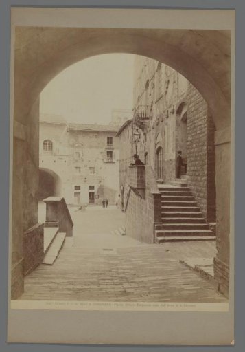 Piazza Vittorio Emanuele seen under the Arco di San Giovanni in San Gimignano, Italy