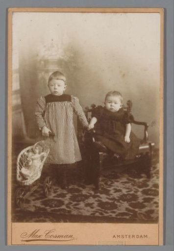 Portrait of two children with a doll pram with a doll