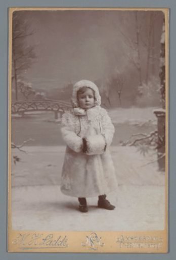 Portrait of a girl in a white fur coat with a muff