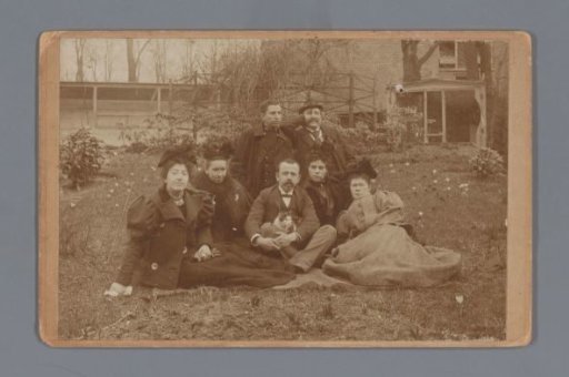 Group portrait of Willem Carel van der Kop and unknown people with a cat in a backyard