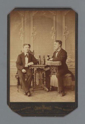 Studio portrait of two unknown men at a table