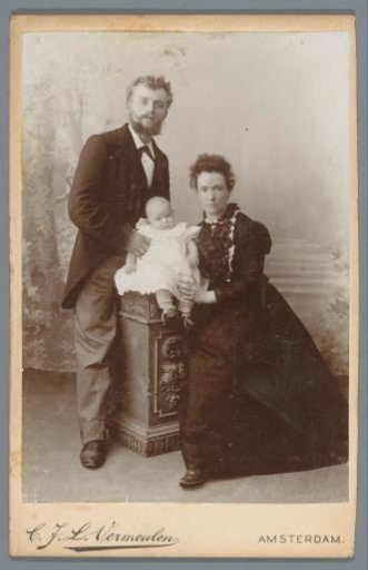 Studio portrait of two parents with a baby